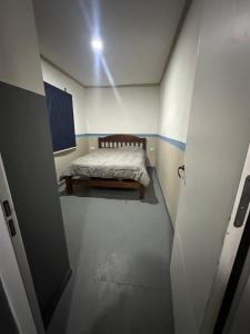 a small room with a bed in a room with a door at Quincho y hospedaje in Reconquista