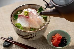 a person is making a bowl of soup with food at Iwaki Washington Hotel in Iwaki