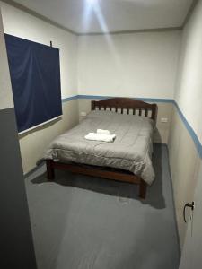 a bed in a room with a blue and white wall at Quincho y hospedaje in Reconquista +6 photos