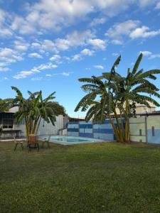 two palm trees next to a swimming pool at Quincho y hospedaje in Reconquista