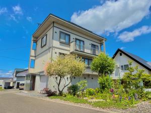 a house with a balcony on the side of it at Snoa Kitanomine - スノア キタノミネ - in Furano