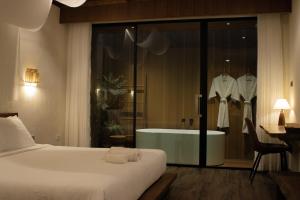 a hotel room with a bed and a bath tub at Inlaya Ratchaburi in Ratchaburi