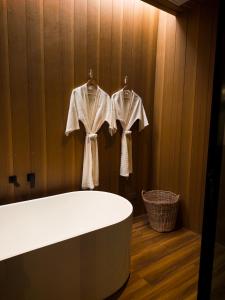a bathroom with a bath tub and two robes at Inlaya Ratchaburi in Ratchaburi +77 photos