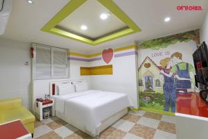 a bedroom with a bed and a painting on the wall at 호텔사랑 in Cheonan