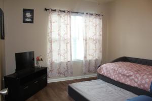 a bedroom with a bed and a television and a window at Regatta Getaway in Fayetteville