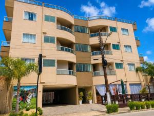 a tall building with trees in front of it at Pousada Recanto do Cowboy in Penha