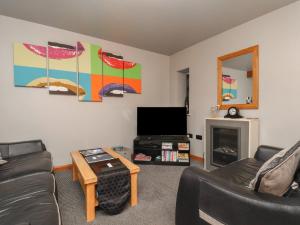 a living room with a couch and a tv at Fortunatus in Whitby