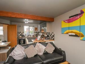 a living room with a couch and a kitchen at Fortunatus in Whitby