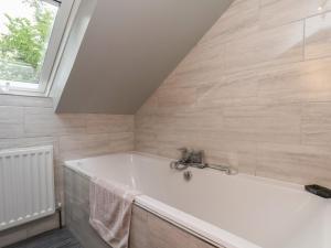 a white bath tub in a bathroom with a window at Fortunatus in Whitby +16 photos