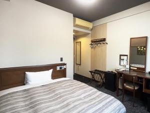 a hotel room with a bed and a desk at Hotel Route-Inn Kanda Ekimae in Kanda
