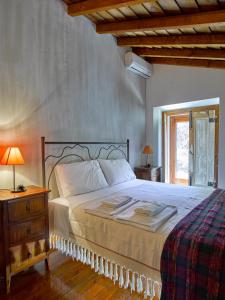 a bedroom with a bed and a table with a lamp at Casas da Estação, Country Houses in Marvão