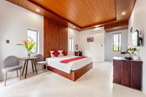 a bedroom with a bed and a desk at Laughter Garden villas in Tân Thành (1) +18 photos