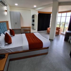 a hotel room with a bed and a living room at Hotel Sun Park Vadodara in Vadodara +14 photos