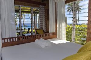 a bed in a room with a large window at Maravu Taveuni Lodge in Matei +117 photos