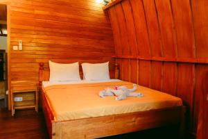 a bed with a stuffed animal laying on it at Banana Leaf Bungalow in Gili Trawangan