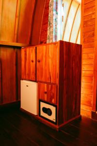 a small refrigerator in a room with wooden cabinets at Banana Leaf Bungalow in Gili Trawangan