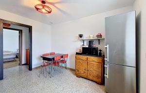a kitchen with a refrigerator and a table and chairs at Elegant Apprt in Lachamp-Raphaël
