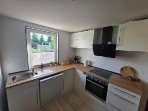 a kitchen with white cabinets and a sink and a window at Haus Thieke in Rhederfeld