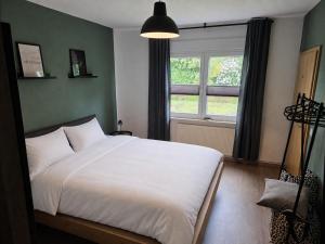 a bedroom with a large white bed and a window at Haus Thieke in Rhederfeld