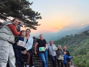 a group of people sitting on the steps of a mountain at BeiJing Mutianyu Hills Pool Wall Resort view at the foot of Mutianyu Great Wall, infinity pool, one-way PEK airport pick-up, free laundry and coffee in Huairou