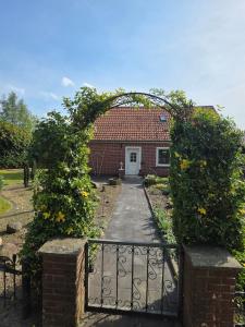 a gate to a brick house with a white door at Haus Thieke in Rhederfeld
