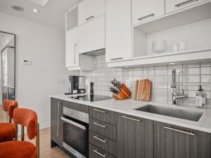 a kitchen with a sink and a stove top oven at VOGUE Suites Toronto in Toronto +44 photos