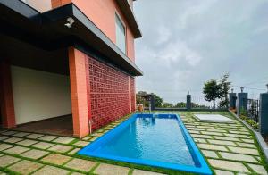 a swimming pool in front of a house at The Miste Munnar By D2V in Munnar
