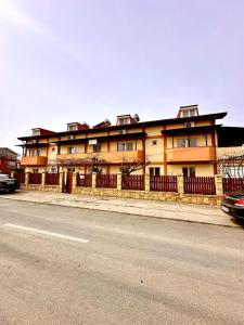 a building with a fence in front of a street at Vila Coralia in Schitul