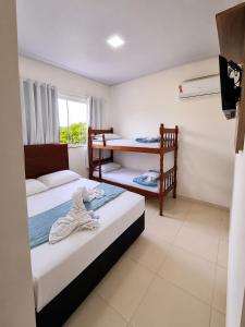 a room with two beds and a bunk bed at Pousada Safari in Penha +23 photos