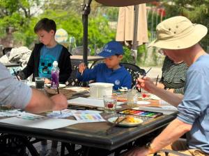 a group of children sitting at a table coloring at BeiJing Mutianyu Hills Pool Wall Resort view at the foot of Mutianyu Great Wall, infinity pool, one-way PEK airport pick-up, free laundry and coffee in Huairou +82 photos