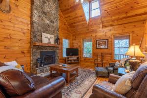 a living room with leather furniture and a fireplace at The Forge in Lansing
