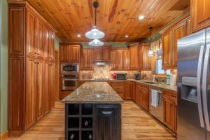 a kitchen with wooden cabinets and a stainless steel refrigerator at The Forge in Lansing