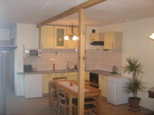 a kitchen with a wooden table and a dining room at Das Haus am See in Grundlsee