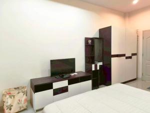 a bedroom with a bed and a tv on a cabinet at Phala Beach Rayong Palm Villa 2BR2BA in Ban Phala