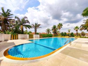 a swimming pool in a resort with palm trees at Phala Beach Rayong Palm Villa 2BR2BA in Ban Phala