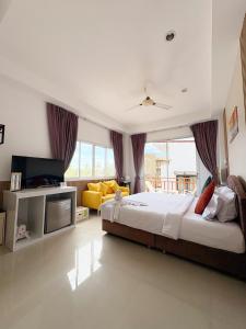 a bedroom with a large bed and a tv at Kata Beachwalk Hotel and Bungalows in Kata Beach