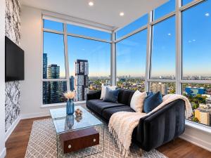 a living room with a couch and large windows at VOGUE Suites Toronto in Toronto