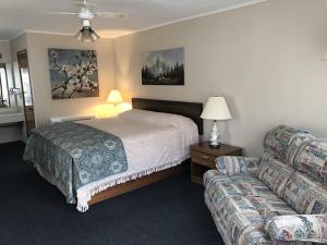 a hotel room with a bed and a couch at Bambi Motel in East Tawas