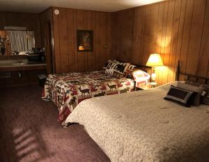 a hotel room with two beds and a table with a lamp at Bambi Motel in East Tawas