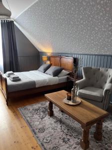 a bedroom with a bed and a couch and a coffee table at 2ÕDE Kodumajutus in Hullo