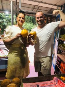 a man and a woman holding oranges in a store at Rekawa Edge Homestay in Netolpitiya