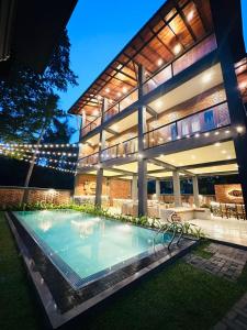 a house with a swimming pool in front of it at Airport Hotel Transit 98 in Katunayaka