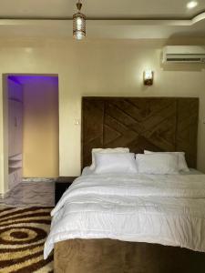 a bedroom with a large bed with a large wooden headboard at Starlight Homes in Asaba