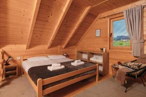 a bedroom with a bed in a log cabin at Green Top Durmitor in Žabljak