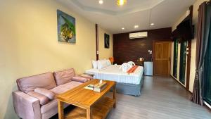 a living room with a couch and a bed at 88 Homestay in Bang Chak