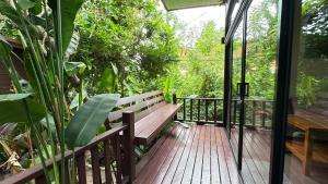 a wooden bench sitting on a wooden deck at 88 Homestay in Bang Chak +18 photos