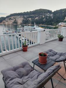 a balcony with chairs and a table and a boat at Avra in Alonnisos