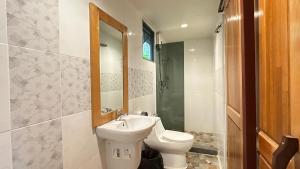 a bathroom with a toilet and a sink and a mirror at 88 Homestay in Bang Chak