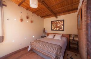 1 dormitorio con 1 cama en una habitación con techos de madera en Solar del Tropico en Huacalera