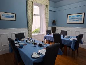 a room with two tables and chairs and a window at Dean Park Guest House in Kilmarnock